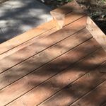 Old concrete step covered with pressure treated wood